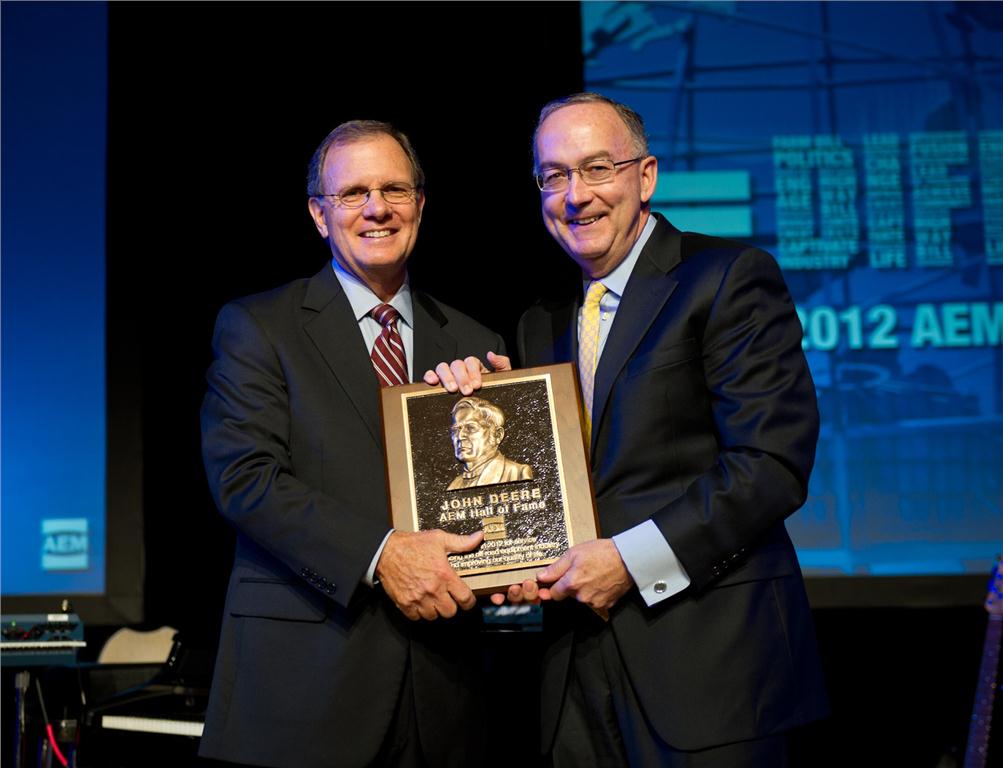 Deere & Company chairman and CEO Sam Allen accepts the AEM Hall of Fame plaque from 2012 chair of the AEM and CEO of Krone, North America, Rusty Fowler.