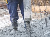 building construction worker pouring cement or concrete with pump tube