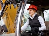 Female construction worker driving an earth mover