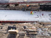 Aerial view of group of workers on construction site, working.