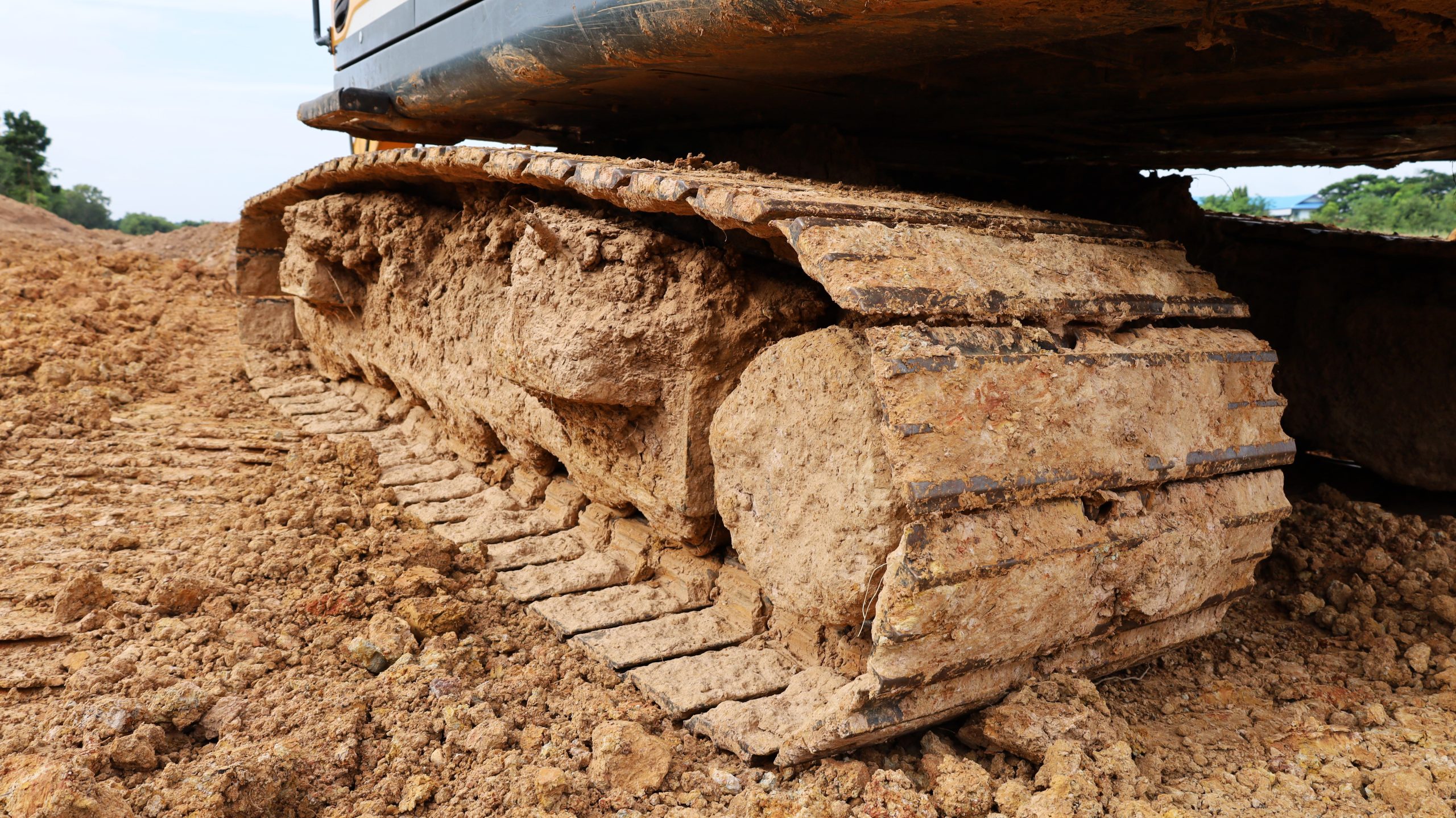 Dirty crawler backhoe. A crawler drive chassis of a heavy backho